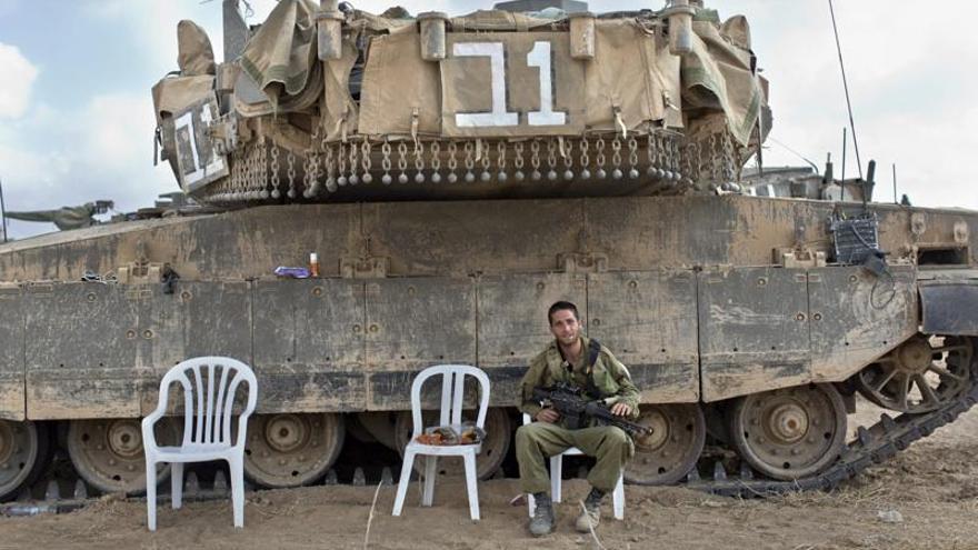 Un soldat israelià seu davant un tanc