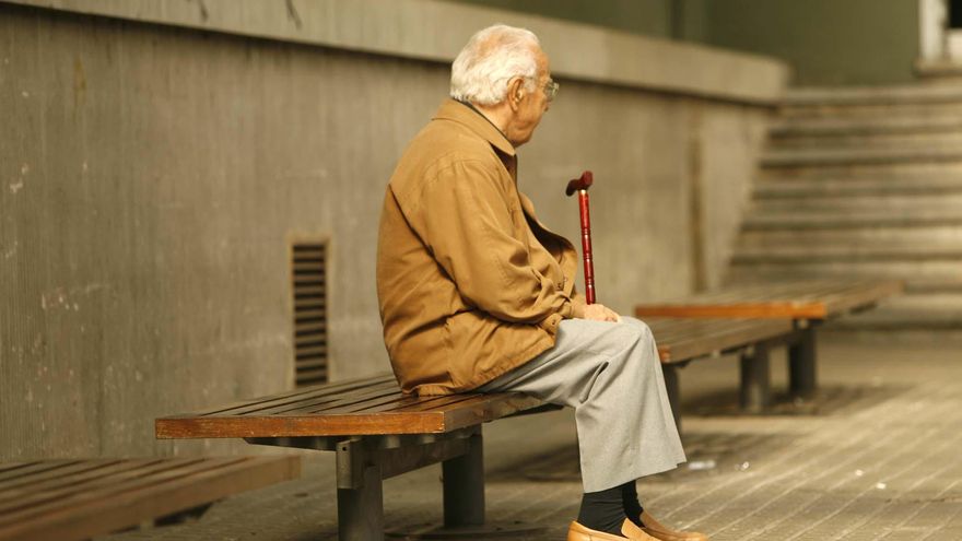 Una persona gran sentada sola en un banc, en una imatge d'arxiu.