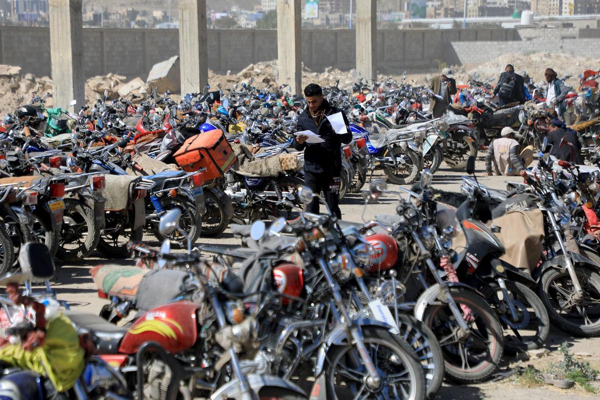 Los yemeníes se reúnen en medio de motocicletas mientras esperan que se les expidan licencias para conducir como parte de una campaña de seguridad de las autoridades huzíes, en Yemen