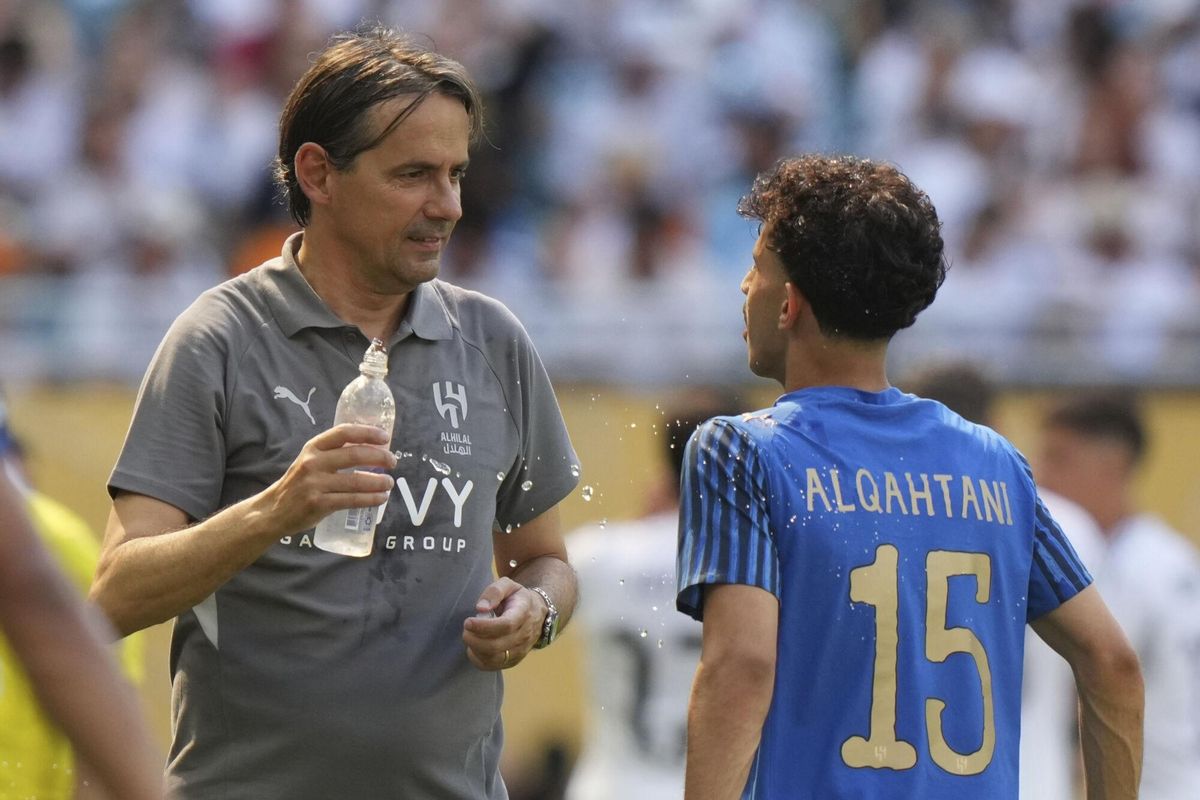 Al-Hilal manager Simone Inzaghi, left, uses water to cool down his player Mohammed Al-Qahtani during the Club World Cup group H soccer match between Real Madrid and Al Hilal in Miami, Fla., Wednesday, June 18, 2025. (AP Photo/Lynne Sladky). EDITORIAL USE ONLY/ONLY ITALY AND SPAIN