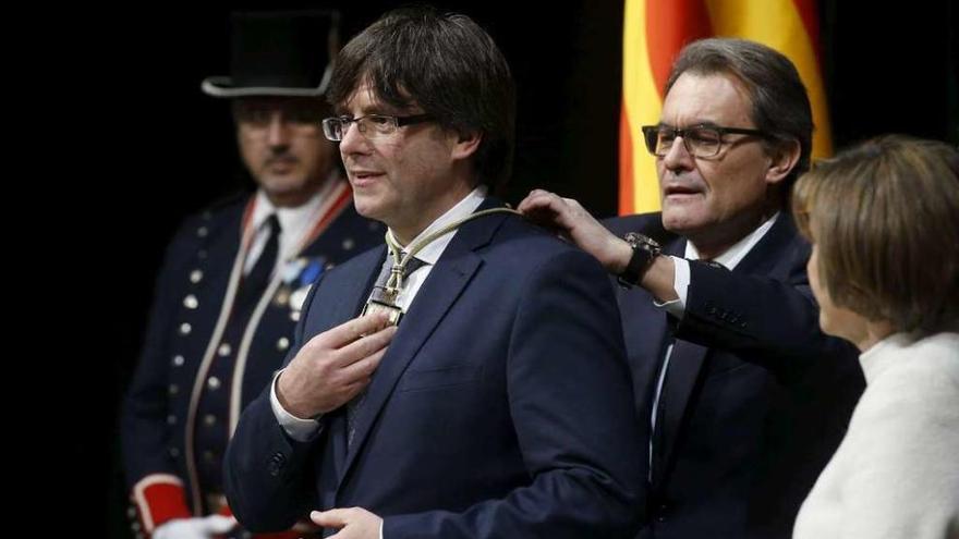 Mas coloca a Puigdemont uno de los distintivos del presidente de la Generalitat. // Reuters