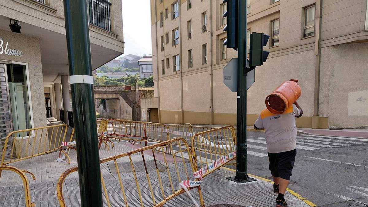 Un operario baja a la calzada para esquivar el vallado en Carril.