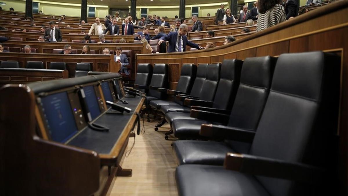 La bancada azul del Gobierno permanece vacía mientras la oposición pide explicaciones al también ausente Luis de Guindos, en el pleno del Congreso.