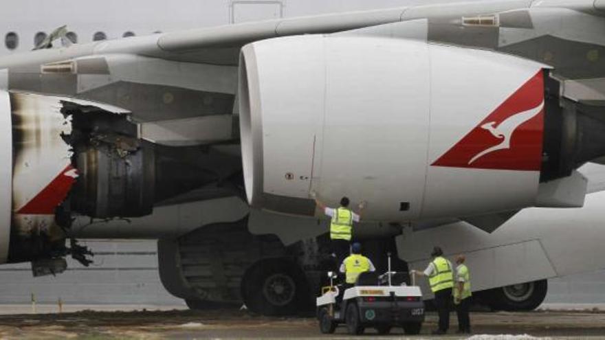 Los técnicos revisan el motor averiado del &#039;Airbus 380&#039; tras aterrizar de emergencia en Singapur. / reuters