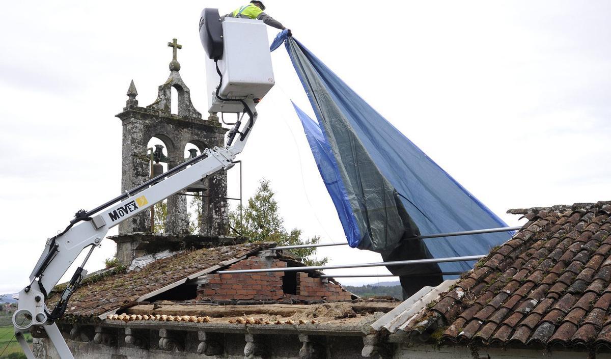 El Concello colocó una lona en la zona donde se desprendió el tejado. | BERNABÉ/JAVIER LALÍN