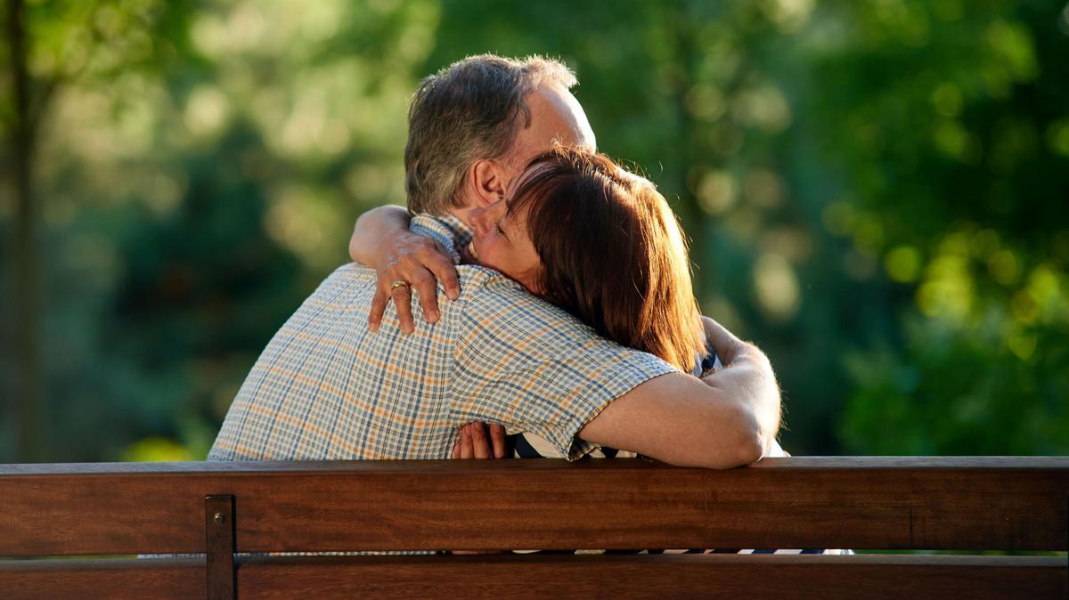 Hugging mature couple on the bench. Man and woman in the park. pareja sexo mediana edad  FOTO: 123RF
