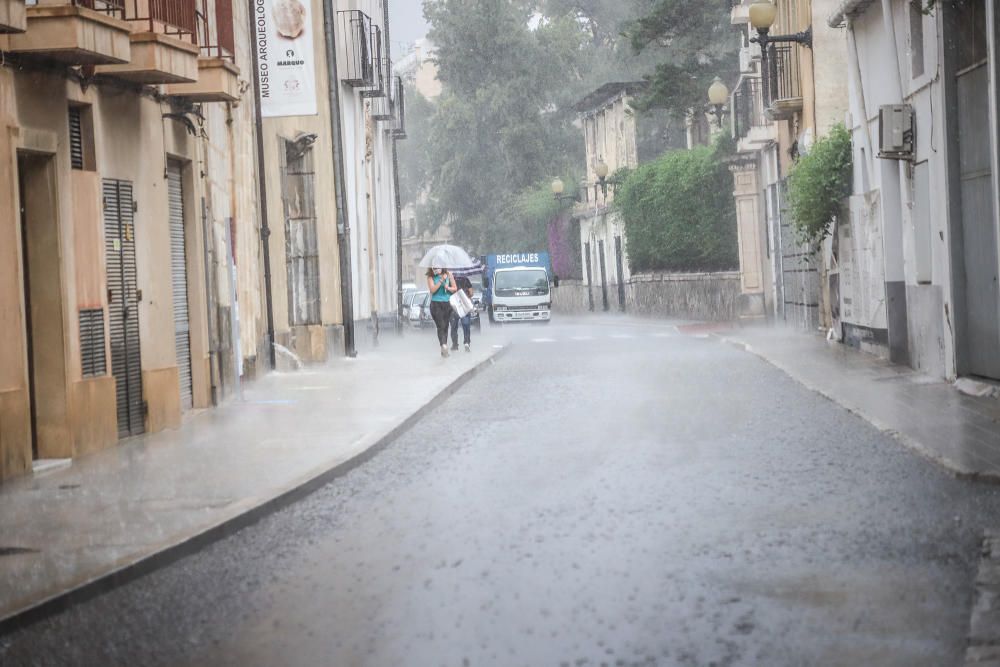 Un buen chaparrón ha sorprendido a primera hora a los peatones en el centro histórico de Orihuela. Las lluvias y tormentas se prolongarán esta tarde con posibilidad de granizo.
