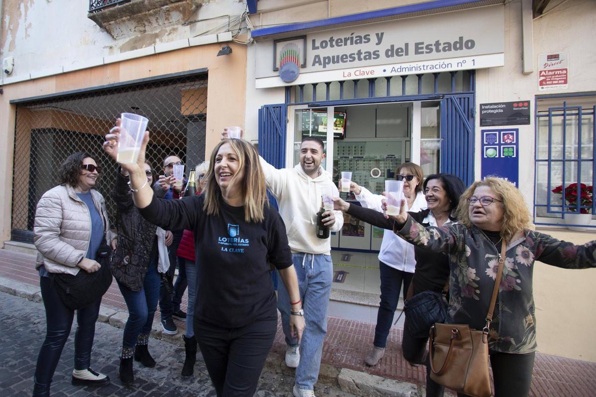 La lotera, en primer plano, brinda con cava