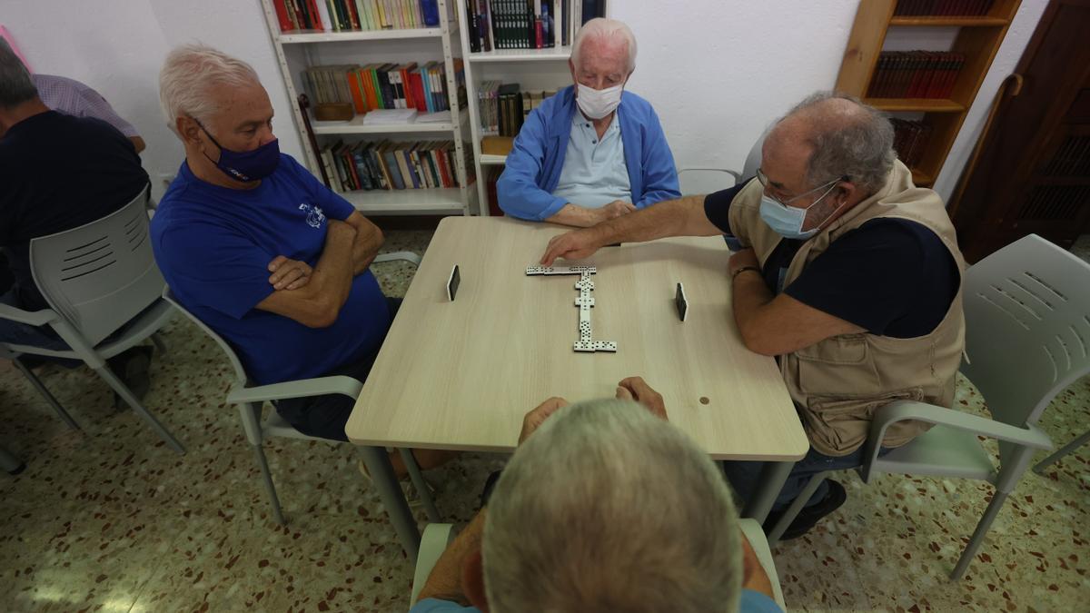 Un grupo de jubilados juega al dominó en un centro de mayores de Alicante.