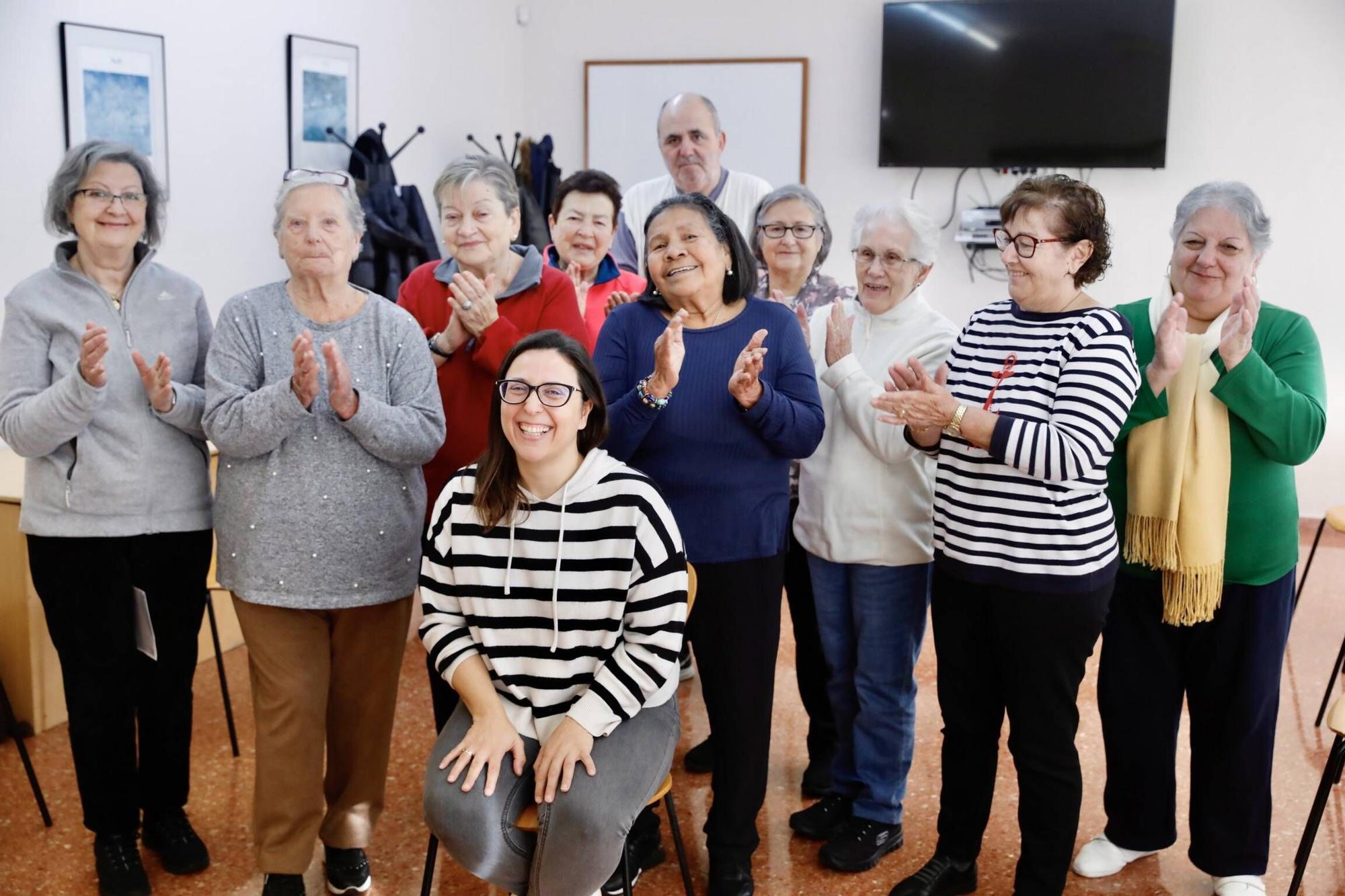 Sentada, Eva del Riego recibe el aplauso de sus alumnos del taller de &quot;Bienestar en el vestir&quot;, del Centro de Mayores de El Llano.