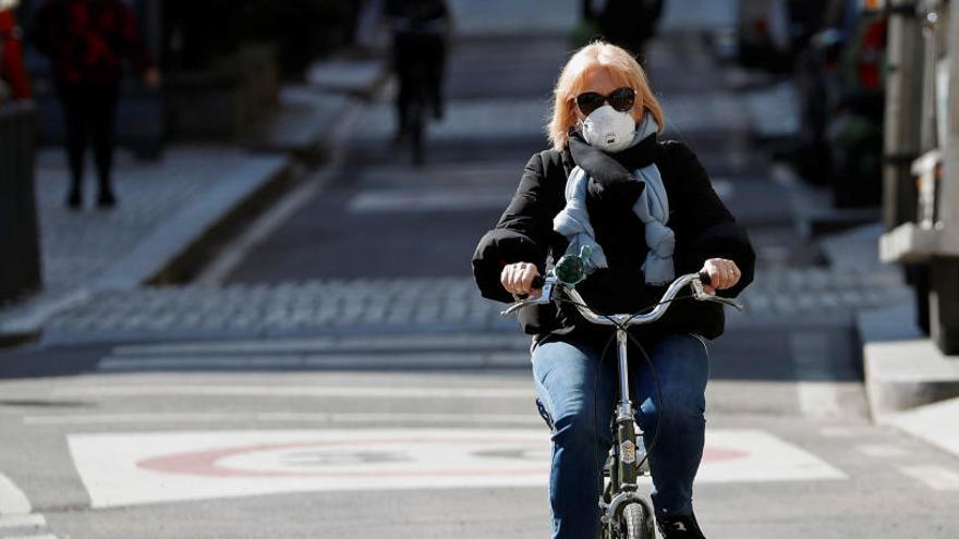 Una dona amb mascarteta circula en bicicleta a Milà