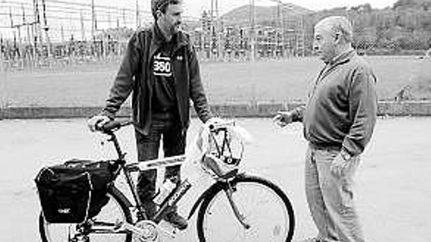 Joaquín Arce, con su bici oficial, con el alcalde de Ribera de Arriba; a la derecha, detalle de logotipo y precio. / luisma murias