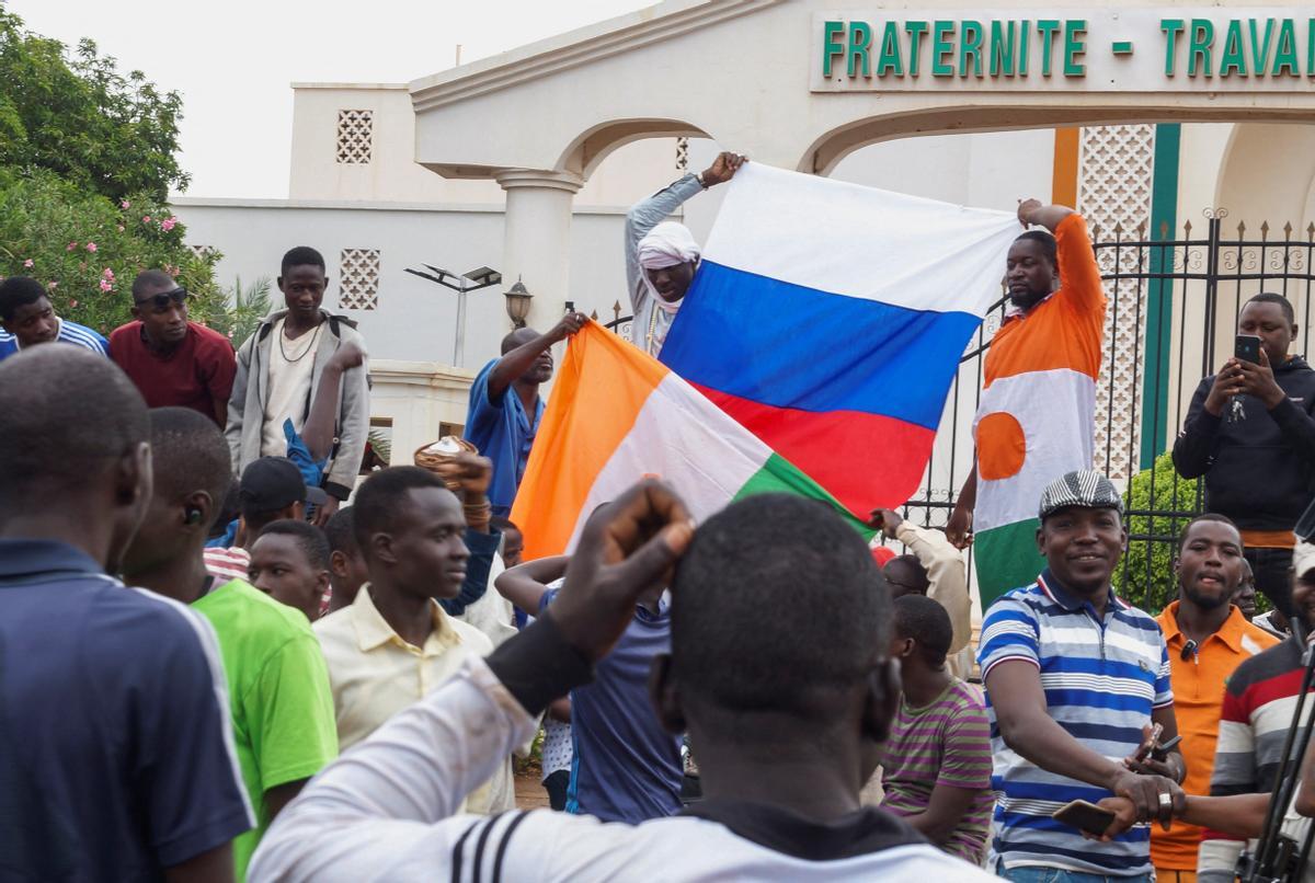 Niamey, Níger, 27 de julio de 2023.- Manifestantes pro golpe en Níger enarbolan la bandera de Rusia