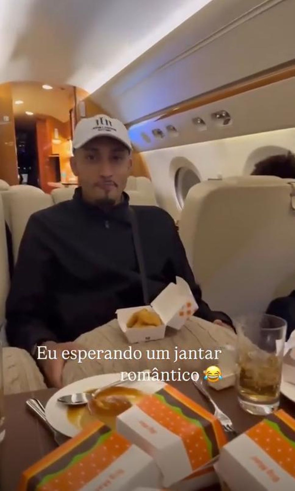 Raphinha a bordo de un avión privado con las hamburguesas del McDonald's.