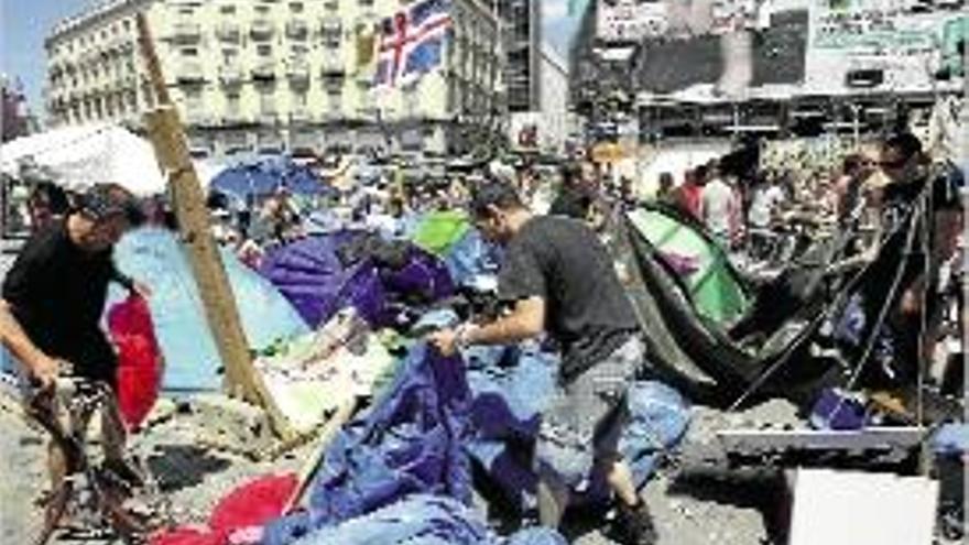 &quot;Indignats&quot; de Madrid, retirant cartells i pancartes durant el dia d&#039;ahir.