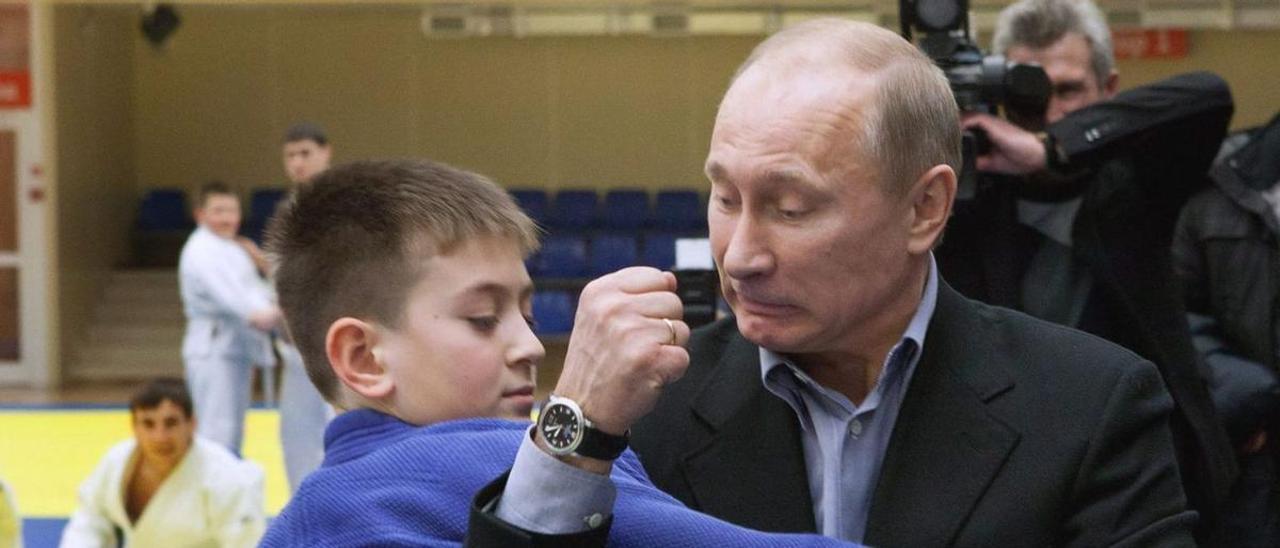 Putin, en 2010, mostrándole una llave de judo a un joven judoca en Rusia.
