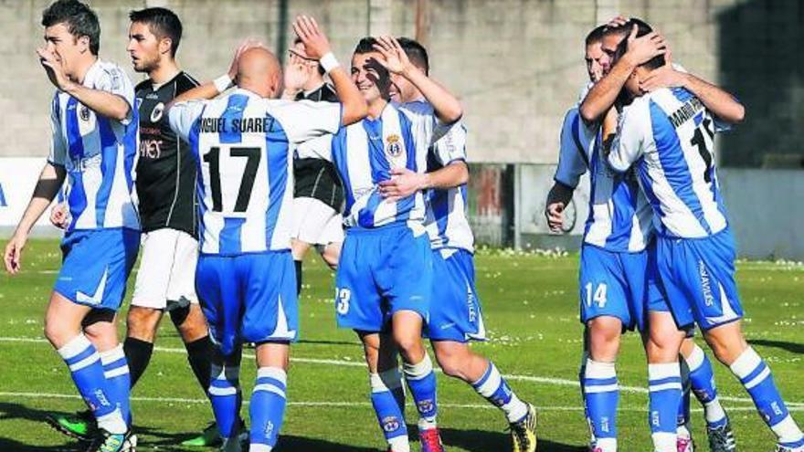 Los jugadores del Avilés celebran el gol de Milio, felicitado por Miguel Suárez, en el centro de la imagen.