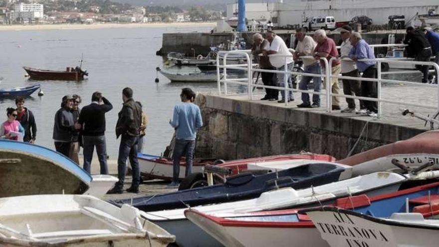 Carmelo Gómez, de espaldas con la mano en la cabeza, entre los actores y técnicos que ensayaban ayer en el muelle, ante un grupo de curiosos.  // Jose Lores