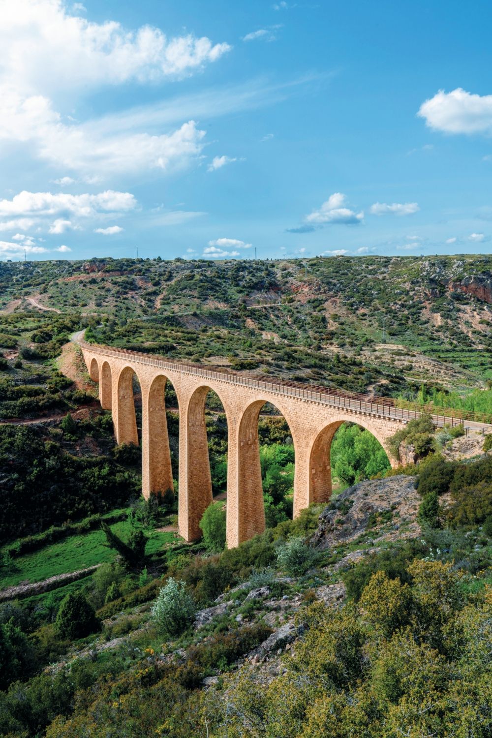 Viaducto de Albentosa, con sus ocho arcos de piedra y 50 metros de altura, es uno de los hitos más espectaculares de la Vía Verde de Ojos Negros, la más larga de España. Este antiguo puente ferroviario, que cruza el río Albentosa en la provincia de Teruel, forma parte del recorrido que une las antiguas minas de Ojos Negros con la costa valenciana, ofreciendo a ciclistas y senderistas un viaje entre historia industrial y paisajes naturales.