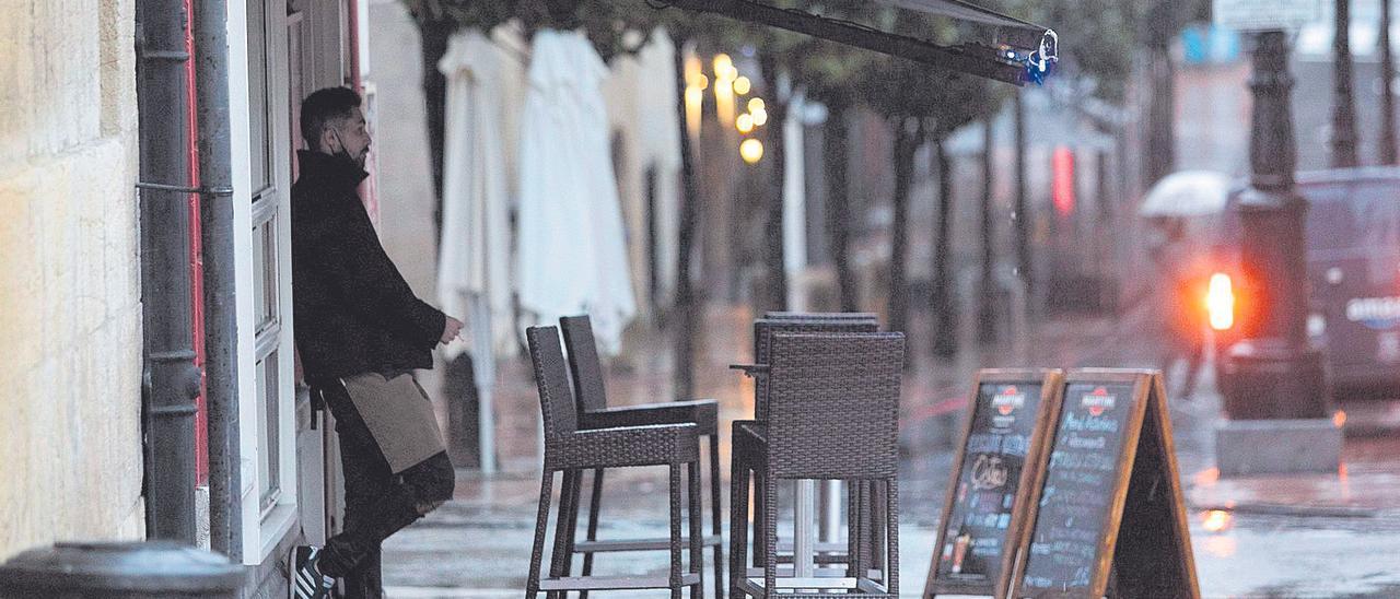 Un camarero de un establecimiento sin clientela de la plaza de Porlier, en Oviedo.