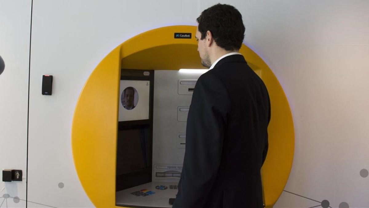 Un usuario saca dinero con reconocimiento facial en un cajero de CaixaBank.