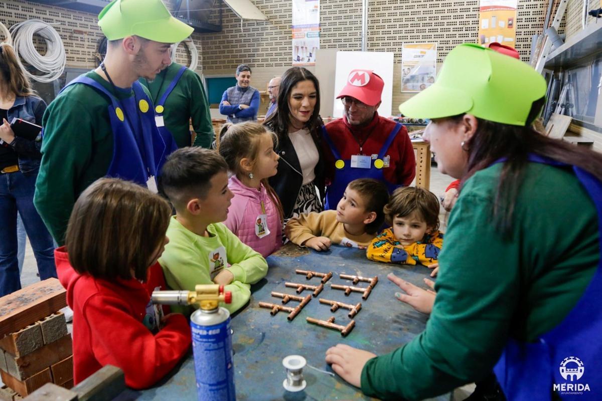 Niños participan en un taller de fontanería del programa Kids Camp, donde aprenden a montar pequeñas piezas de tubería durante una actividad práctica.