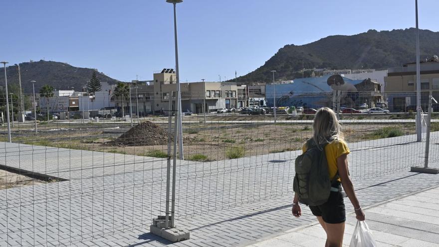 Una mujer pasa ante los 
terrenos del plan Rambla, 
en Cartagena.  iván urquízar