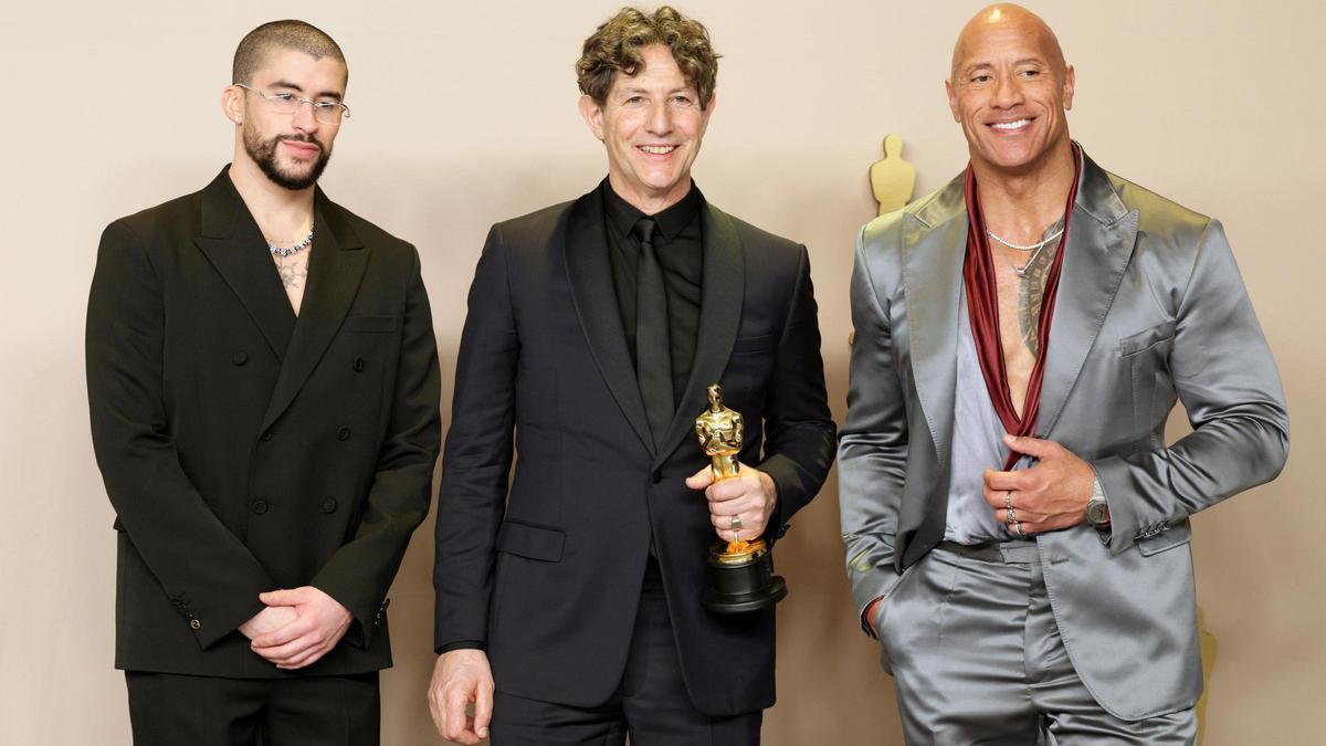 Jonathan Glazer (centro) posa con Bad Bunny y Dwayne Johnson en la gala de los Oscar.mia en el Dolby Theatre del barrio de Hollywood.