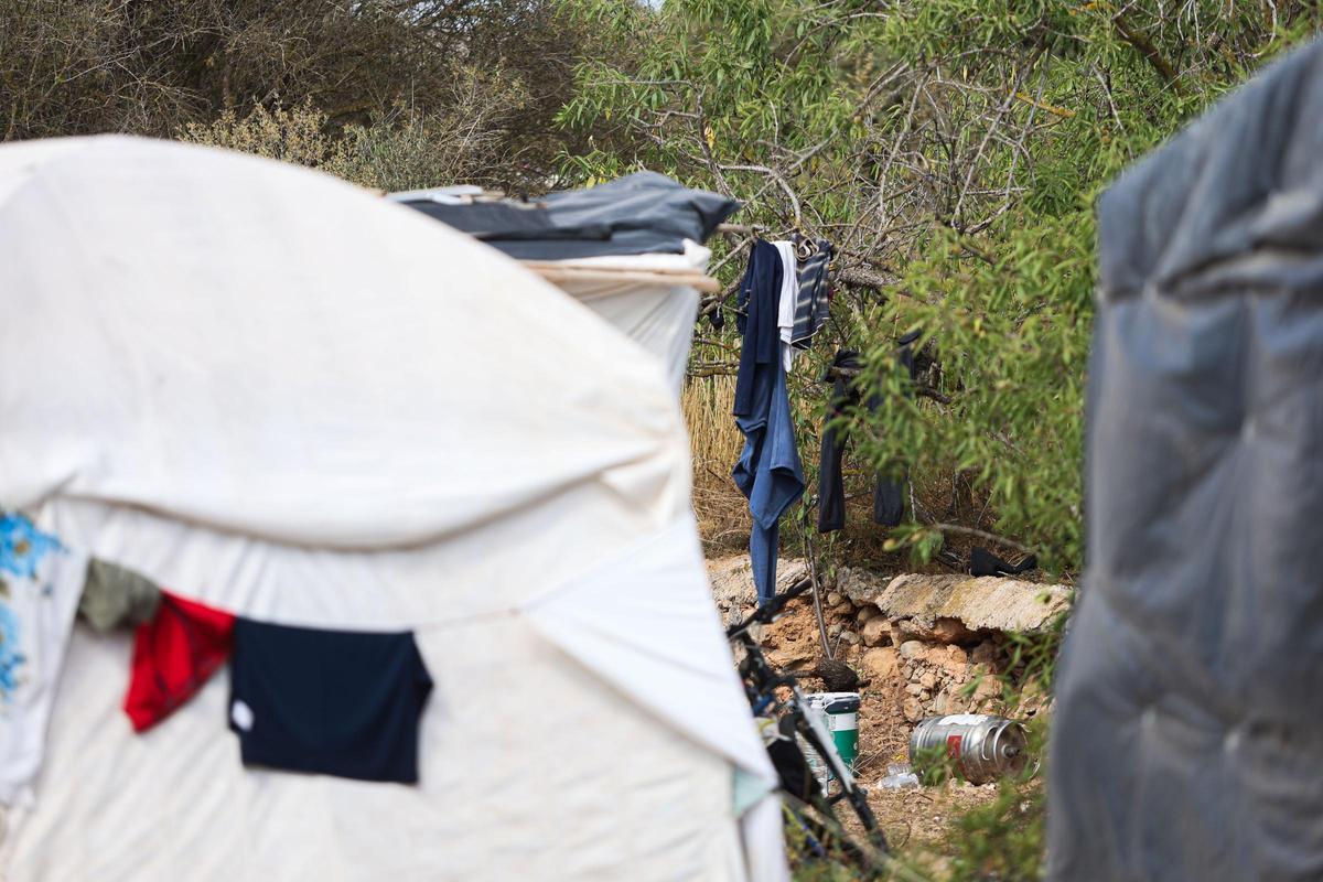 Varias chabolas en un descampado.