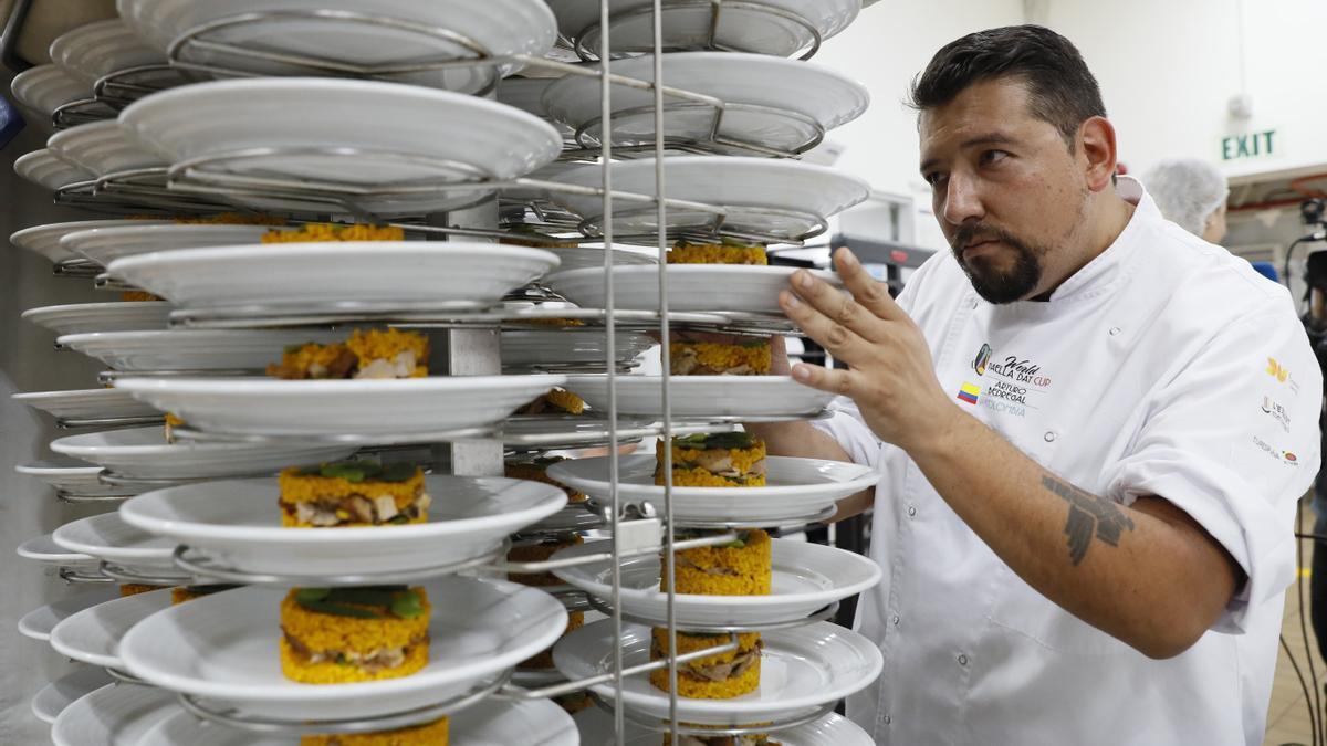 El chef colombiano Arturo Bedregal apila platos de paella, el 16 de noviembre de 2023, en Bogotá (Colombia).