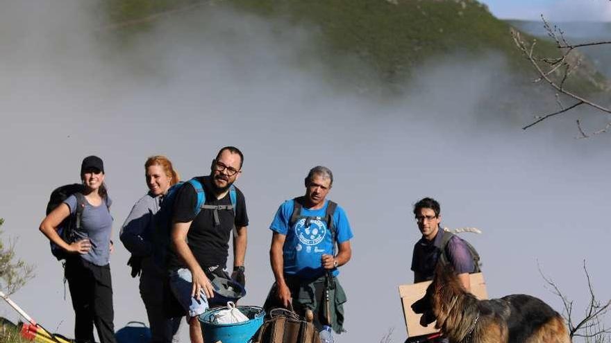 Carlos Tejerizo (dcha.), con su equipo en Casaio, entre ellos la perra pastor que le acompaña. // FdV