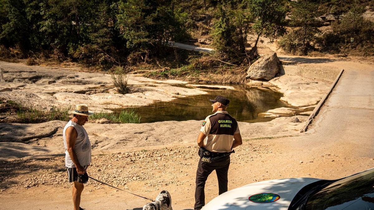 Un guarda rural informa un dels visitants de la riera de Merlès sobre les restriccions vigents