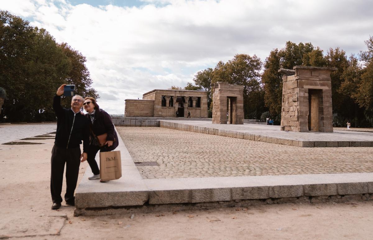 Dos personas se hacen un 'selfie' con el templo de fondo.