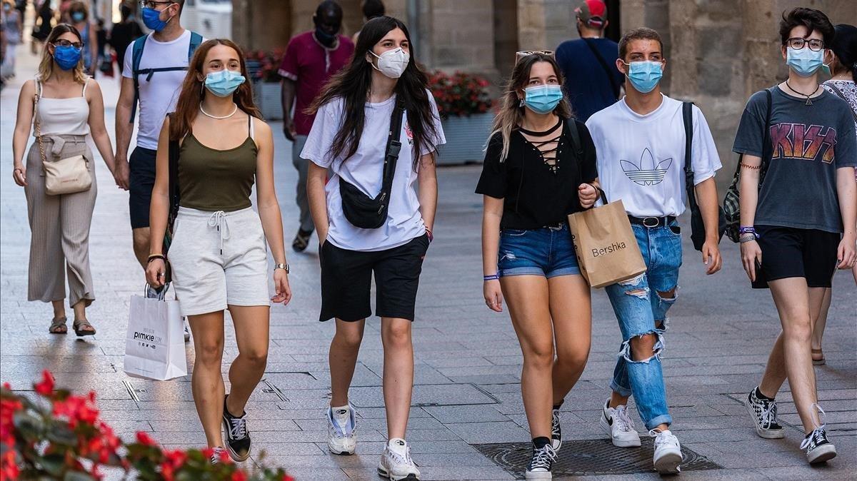 Jóvenes protegidos con mascarillas, paseando por el centro de Lleida.