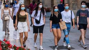 Jóvenes protegidos con mascarillas, paseando por el centro de Lleida.