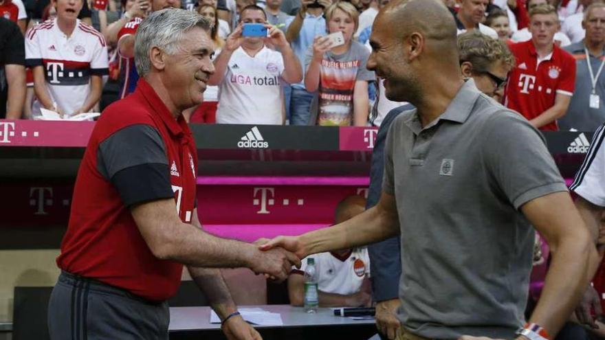 Ancelotti y Guardiola se saludan antes de comenzar el encuentro. // Reuters