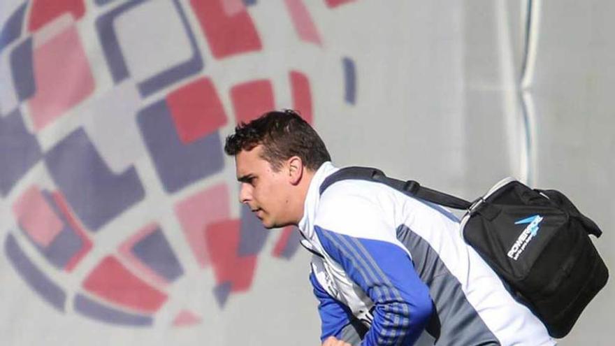 El fisioterapeuta Diego Suárez ayuda a levantarse a Christian Fernández tras el golpe que se dio en el entrenamiento de ayer.