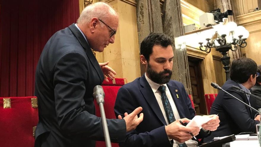 El presidente del Parlament, Roger Torrent, asistido por el secretario general de la Cámara, Xavier Muro.