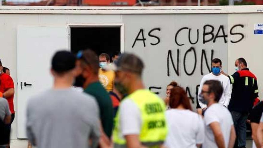 Trabajadores en la entrada de San Cibrao, ayer, donde puede leerse &#039;As cubas non se paran&#039;.