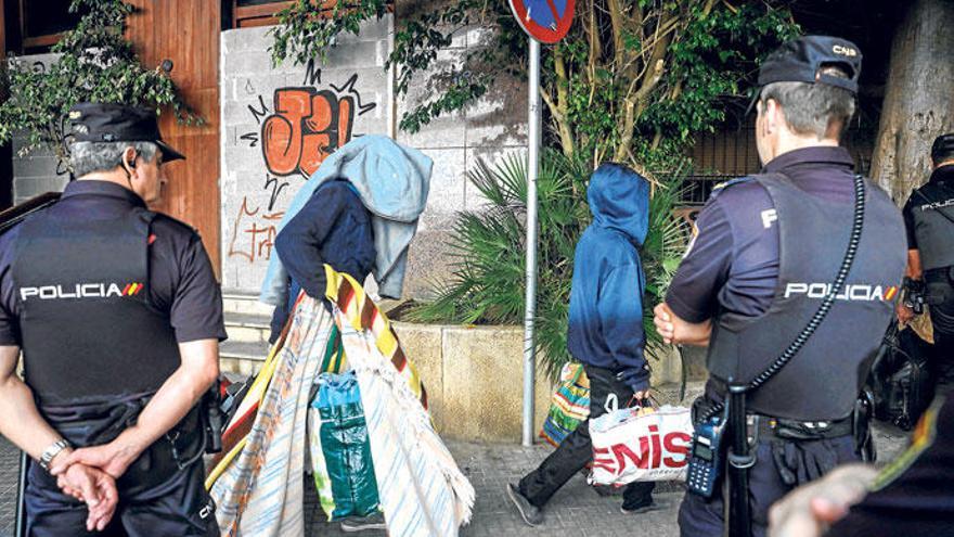 Polizisten der Nationalpolizei überwachen die Räumung eines besetzten Gebäudes in Palma.