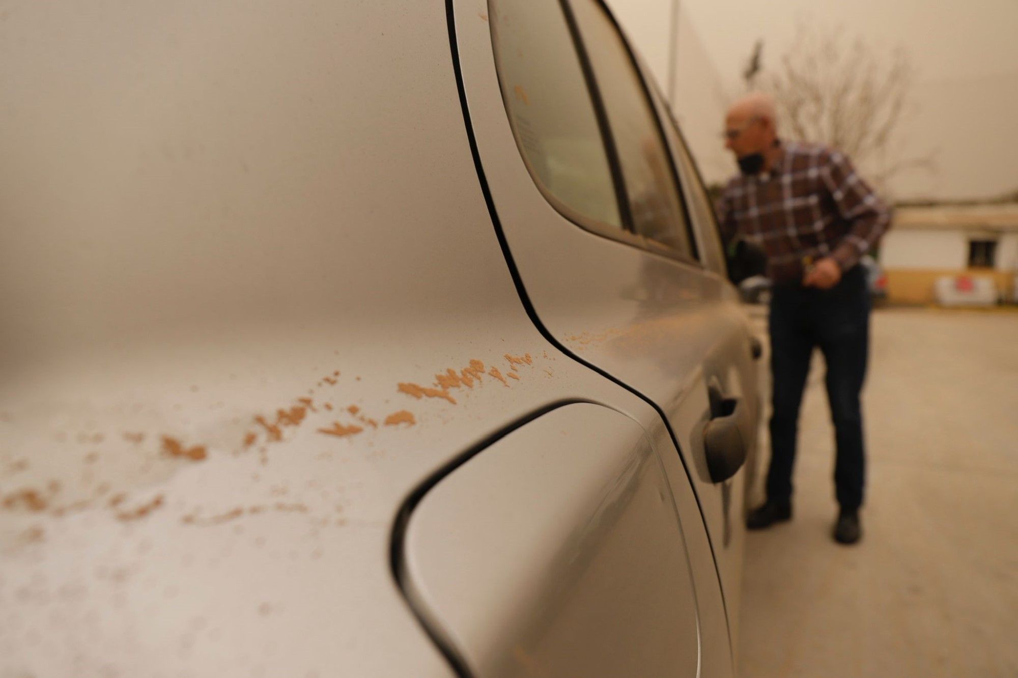 La calima deja el cielo de Málaga de color naranja y los coches llenos de polvo