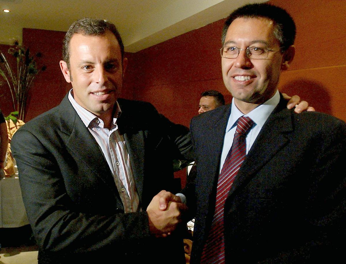 El vicepresidente deportivo del F.C. Barcelona, Sandro Rosell (i), y el directivo responsable de la sección de baloncesto, Josep María Bartomeu, se estrechan la mano tras las ruedas de prensa que ambos han ofrecido esta mañana en las que han anunciado sus dimisiones de la junta directiva del club por graves desavenencias con el presidente Joan Laporta.