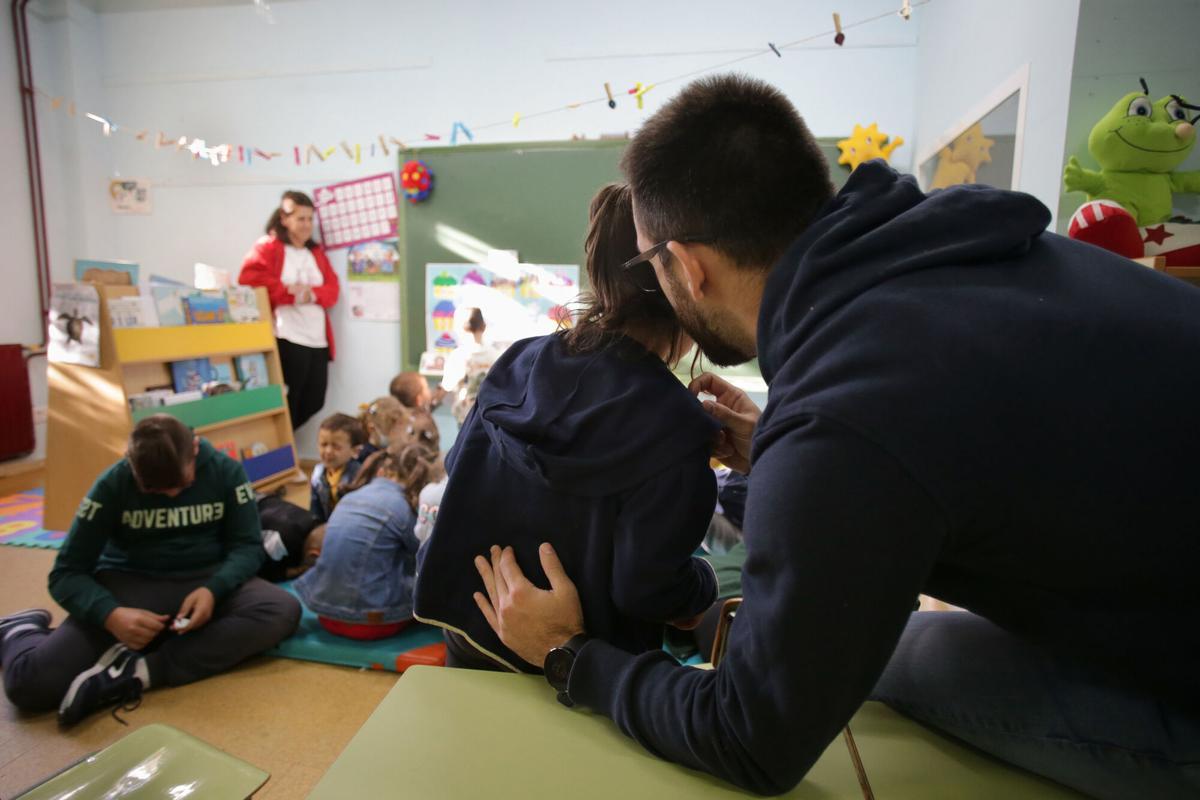 Un profesor ayuda a un alumno de Primaria.