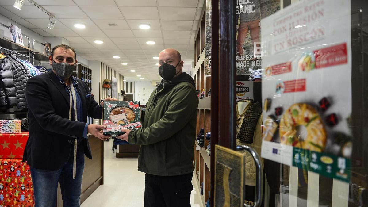 El presidente de Zona Centro de Plasencia regala un roscón a un cliente, este martes.