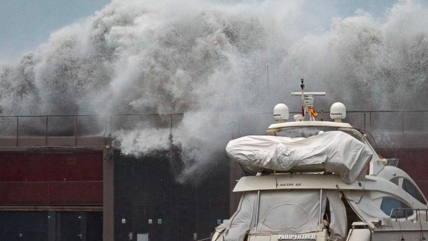 Grandes olas sobrepasan el espigón del Puerto Olímpico de Barcelona.