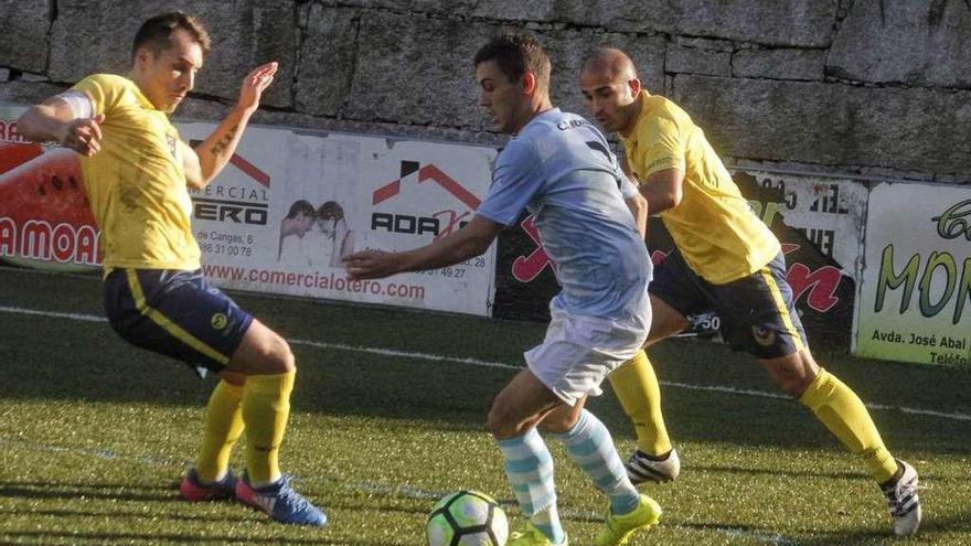 Un futbolista del Moaña trata de eludir a dos rivales en el partido ante el Sanxenxo. // Gonzalo Núñez