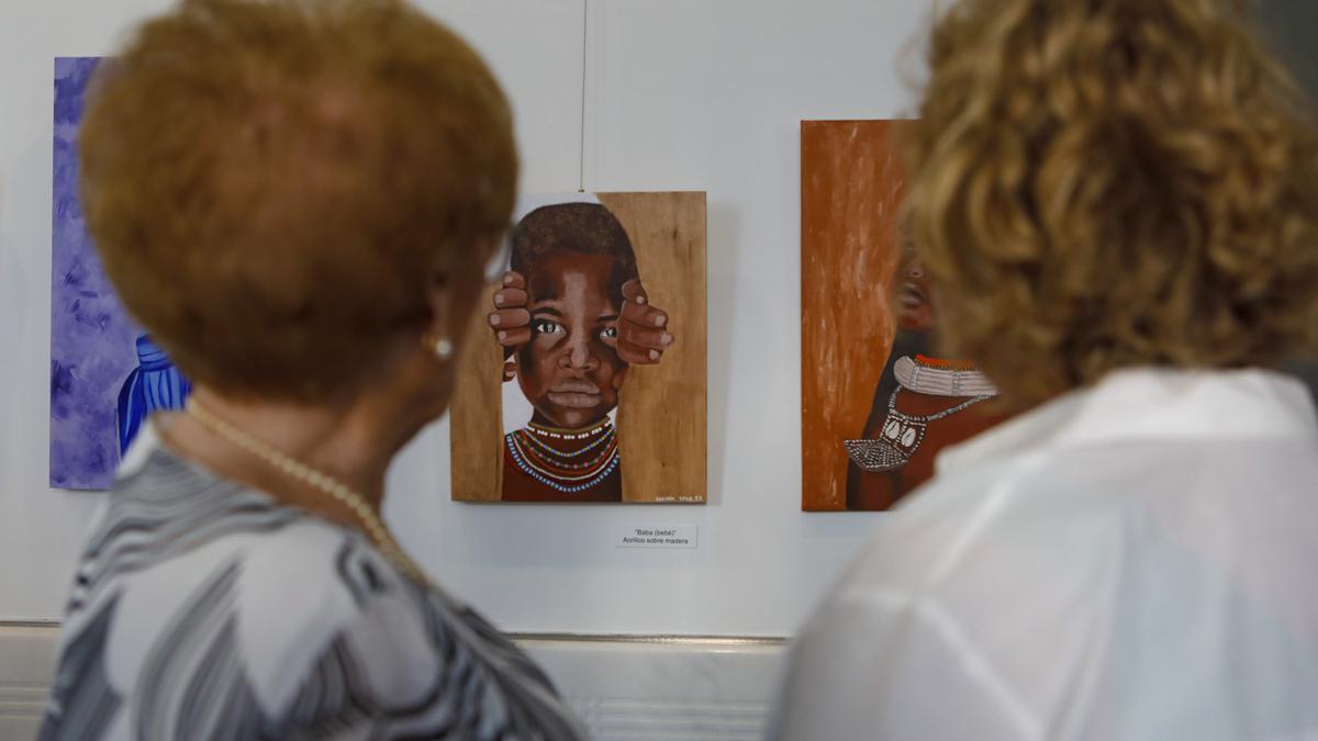 Dos mujeres observan una de las obras de la muestra.