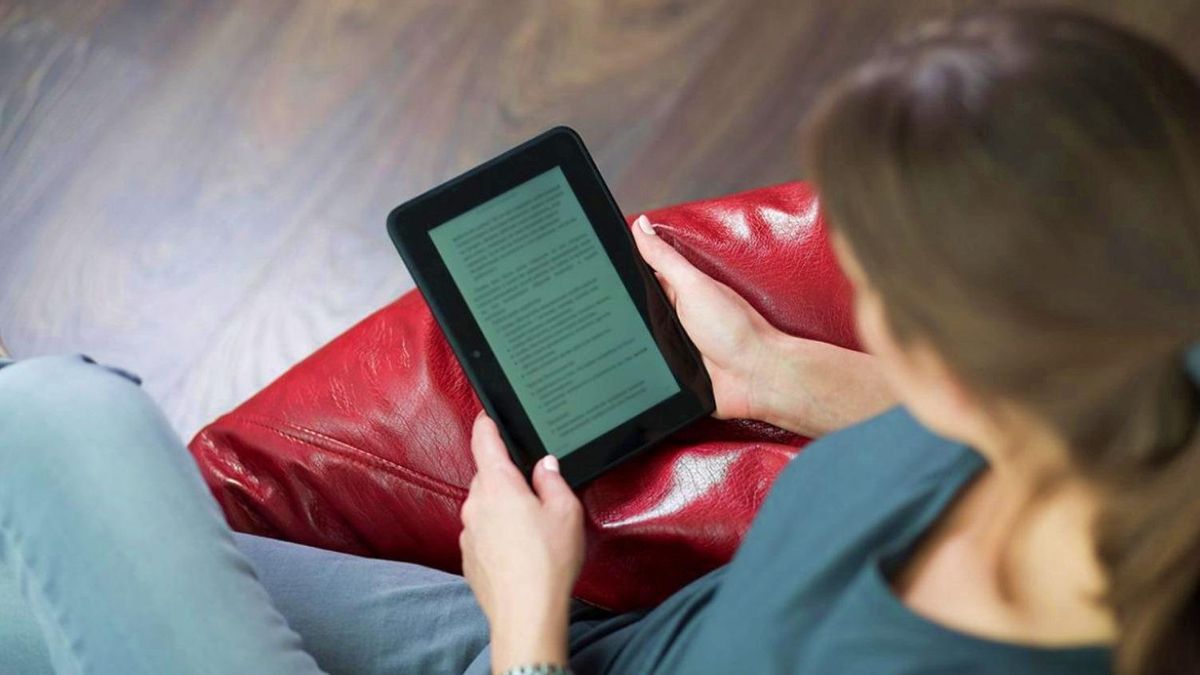 Una mujer, leyendo un libro en un e-reader.