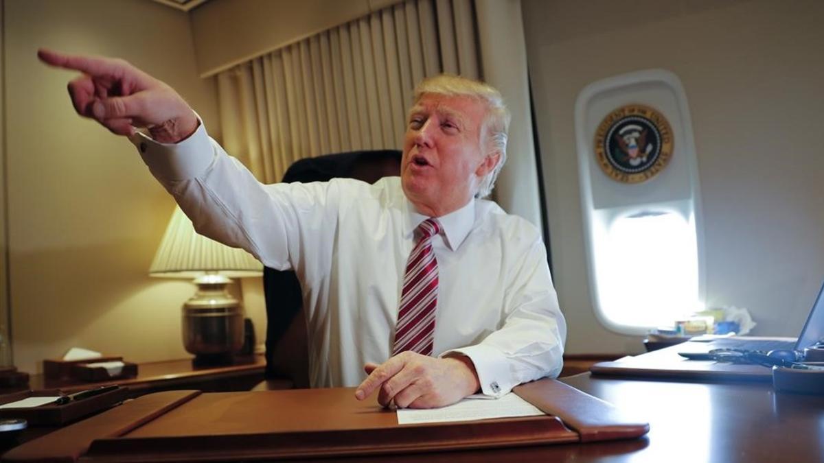 Trump señala a miembros de la prensa, sentado en su despacho del Air Force One, el 26 de enero.