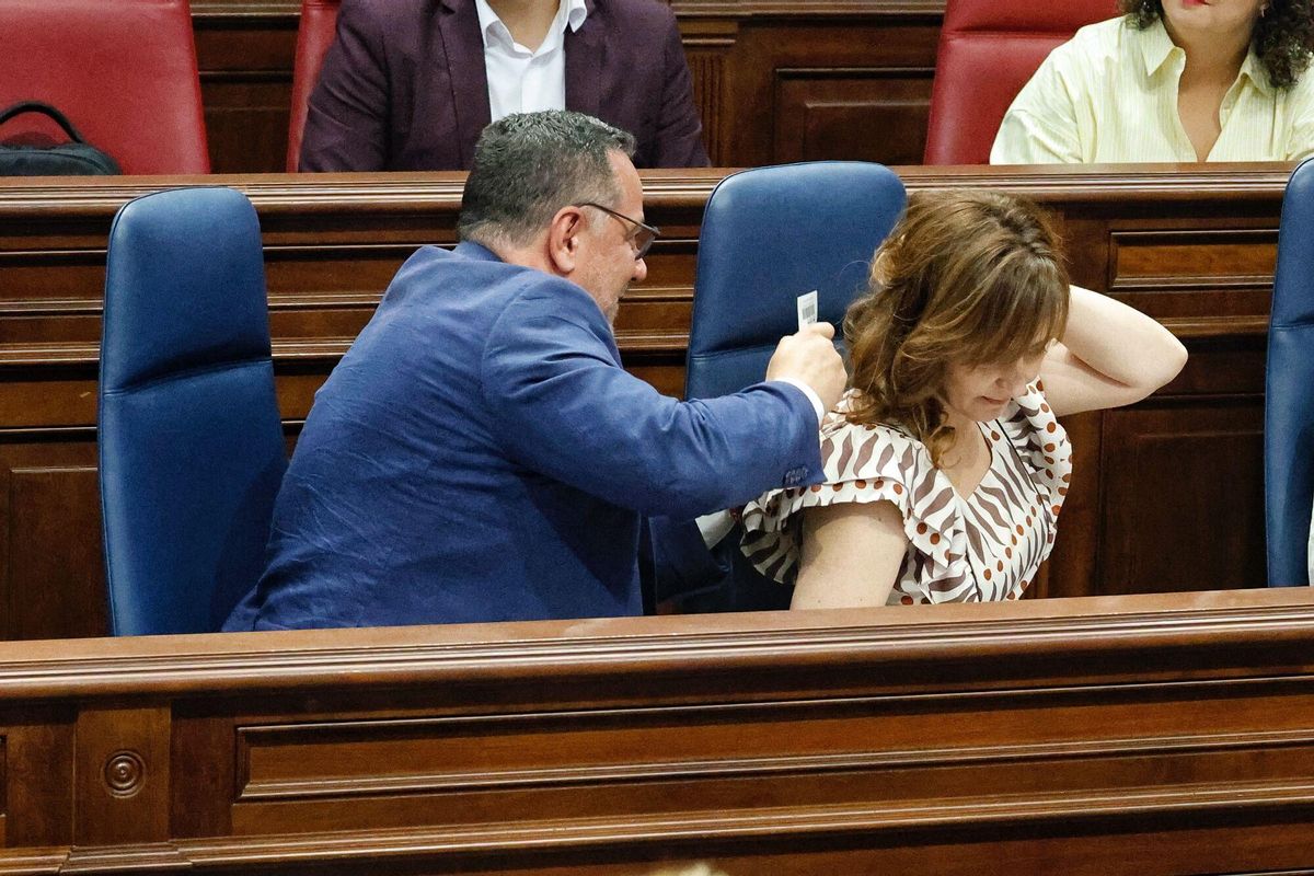 Poli Suárez le quita la etiqueta del vestido a Nieves Lady Barreto, durante el pleno.